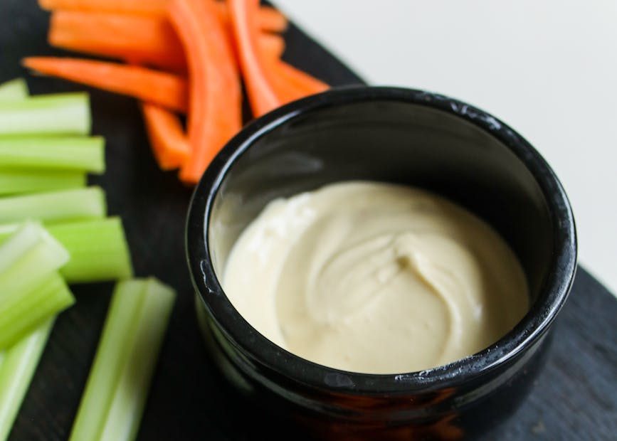 fresh sliced vegetables served with sauce in black bowl on tray